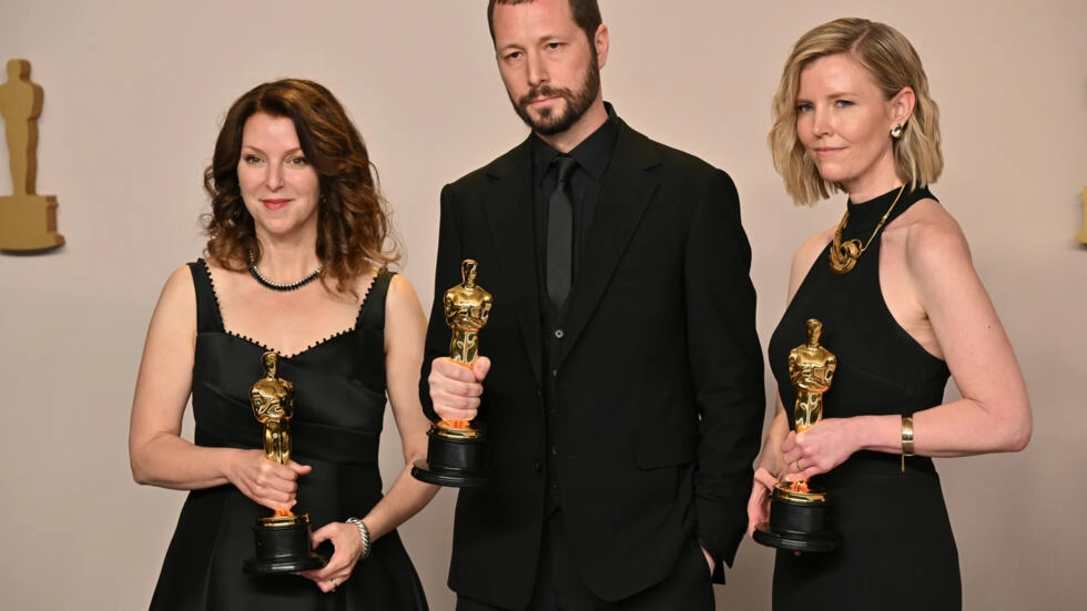 Ukrainian filmmaker Mstyslav Chernov, centre, with his Oscar alongside producers Raney Aronson-Rath, left, and Michelle Mizner © Robyn BECK / AFP